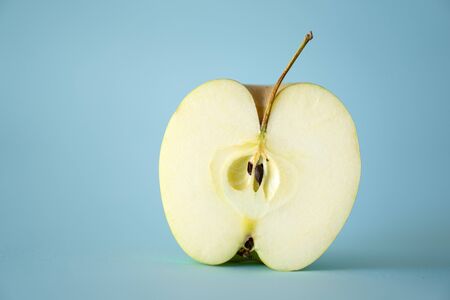 cut half apples and kernels with blue background