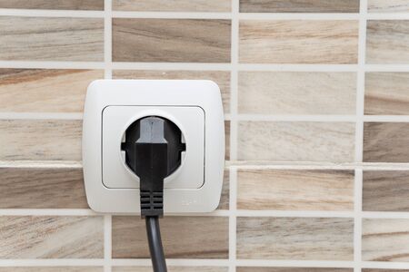electrical outlet on the kitchen wall, on the tilesの写真素材