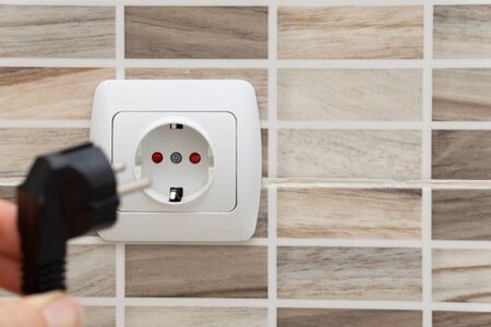 Installing plug into the electrical outlet on the wallの写真素材