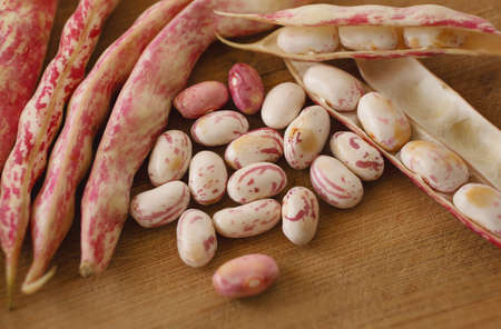 Kidney beans and peeled beans on wooden board