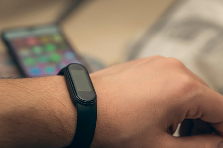 watch with digital smart bracelet and phone in the background