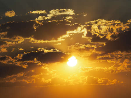 sunset sky view, sun setting among cloudsの写真素材