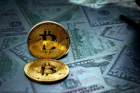 metal bitcoin crypto currency standing on dollar floorの写真素材