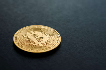 bitcoin crypto currency in gold color on black backgroundの写真素材