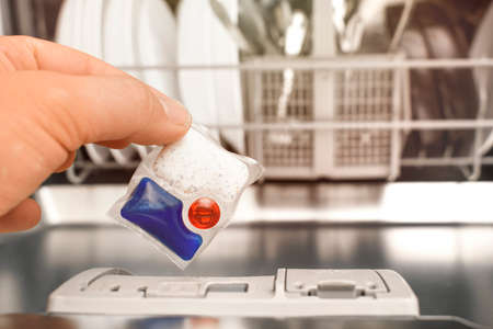 putting tablet detergent in the dishwasher detergent sectionの写真素材