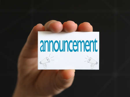 man holding card showing new announcementの写真素材