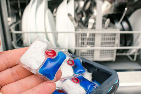putting tablet detergent in the dishwasher detergent sectionの写真素材