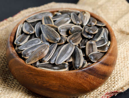 Roasted sunflower seeds in a brown bamboo bowl. It is eaten as nuts in Turkey.