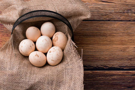 natural chicken eggs in a black basketの写真素材