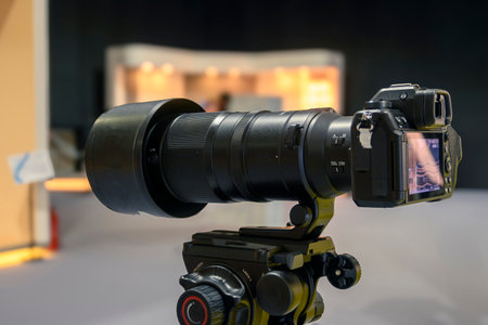digital mirrorless camera with telephoto lens on tripod