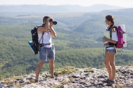 Two tourists  Man photographs woman, she is holding a map の写真素材