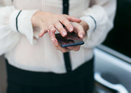 Young beautiful woman writes an SMS to your mobile phone の写真素材