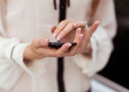 Young beautiful woman writes an SMS to your mobile phone 