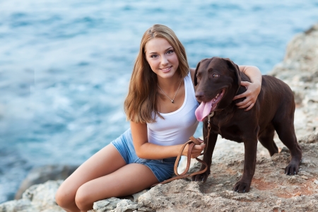 Portrait of a woman with her beautiful dog sitting outdoors の写真素材