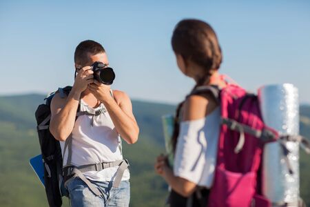 Two tourists  Man photographs woman, she is holding a map の写真素材