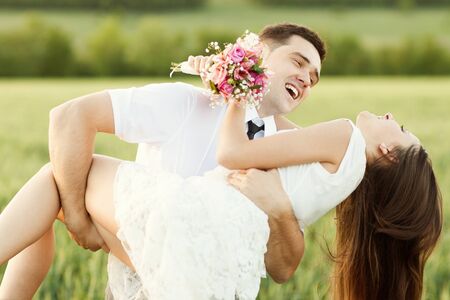 just married couple kissing on the sunset in the fieldの写真素材