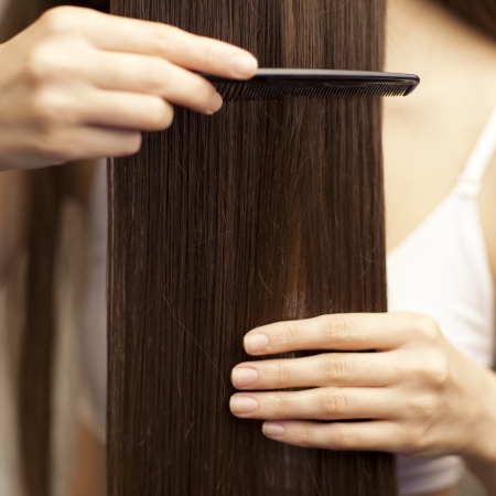 young girl combing her healthy long hair - isolated on whiteの写真素材