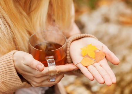 Female hands with hot drink, on light backgroundの写真素材