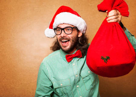 Hipster Santa Claus running with the bag of the presentsの写真素材