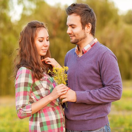 couple in love, boy gives a girl a bouquet of wild flowersの写真素材