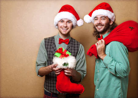 Two emotional Santa Claus  dressed in clothes hipster with the bag of the presentsの写真素材