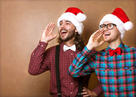 two guys in hipster clothes of Santa Claus in a Christmas shoutの写真素材