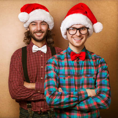 Two emotional Santa Claus  dressed in clothes hipster standing near a wall - copy Spaceの写真素材