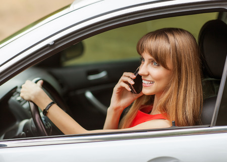 Businesswoman in the car on the phone.の写真素材
