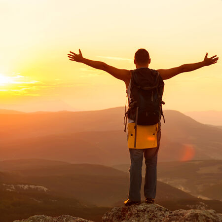 guy in the mountains at sunset. the concept of freedomの写真素材