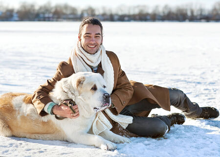 Man and central Asian shepherd walk in the park