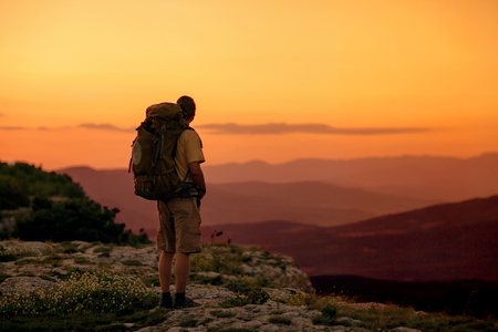 hiker enjoying sunrise from top of a mountainの写真素材