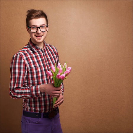 A young romantic man holding a bouquet of flowers  isolated on white backgroundの写真素材