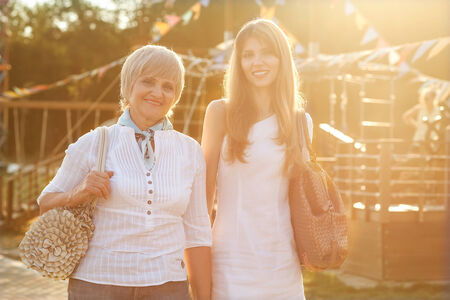 Adult mother and daughter after shopping walk down the street and talk