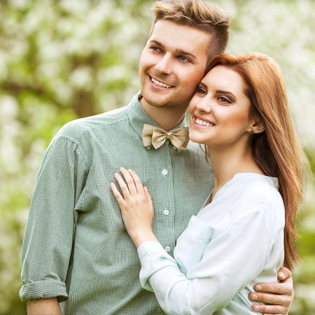 couple in love in blooming apple trees garden, smiling . Valentine's Dayの写真素材