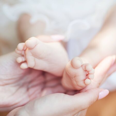 newborn baby feet on female hands