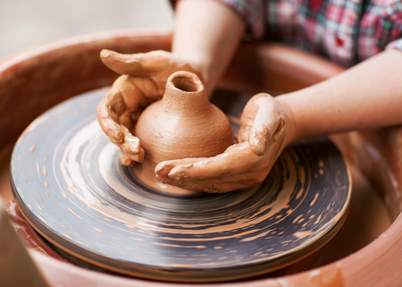 Hands working on pottery wheelの写真素材