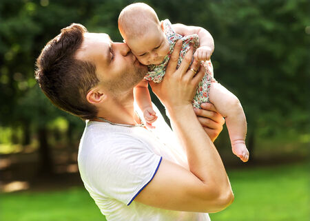Father and baby daughter playing in the park in lovedad and baby daughter playing in the park in...