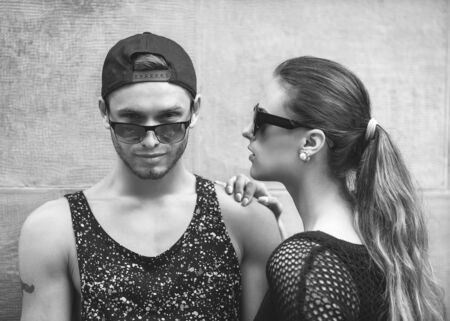 fashion couple with sunglasses  near the wall graffitiの写真素材