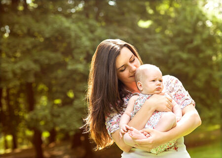 Portrait of happy loving mother and her baby outdoorsの写真素材