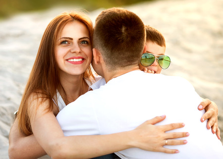 parents with son cuddling in parkの写真素材