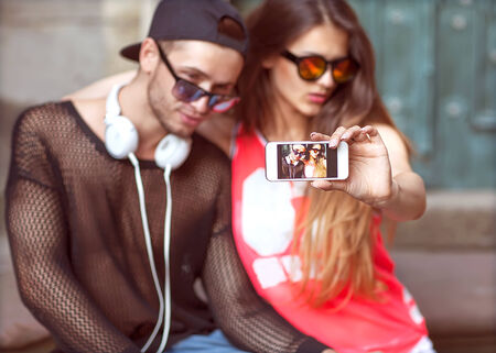 Young fashion couple taking selfie in the cityの写真素材
