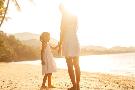 mother and daughter  in the beach at sunset happyの写真素材