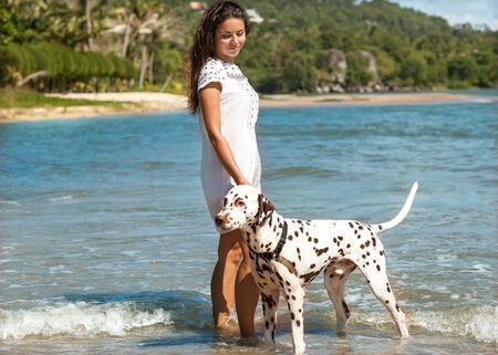 girl at sea with the dog Dalmatianの写真素材