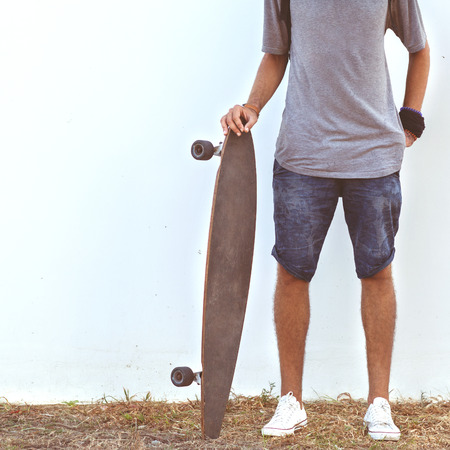 guy on skateboard at sunset near white wallの写真素材