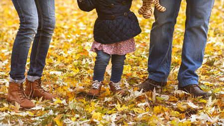 Family with a small daughter walk in autumn parkの写真素材