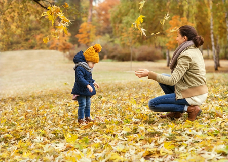 Mother and daughter having fun in the autumn park