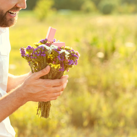 engagement, the guy with a bouquet of flowers and a ringの写真素材