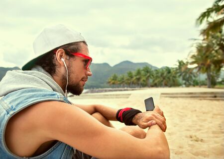 freelancer working guy sitting on the beach with views of palm treesの写真素材