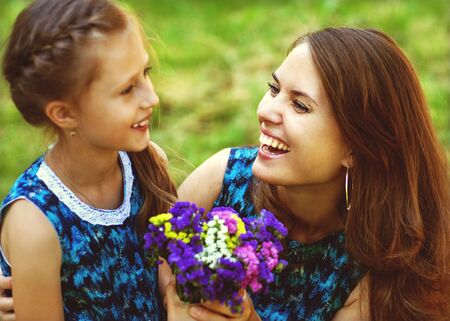 mother and daughter hugging in love playing in the parkの写真素材