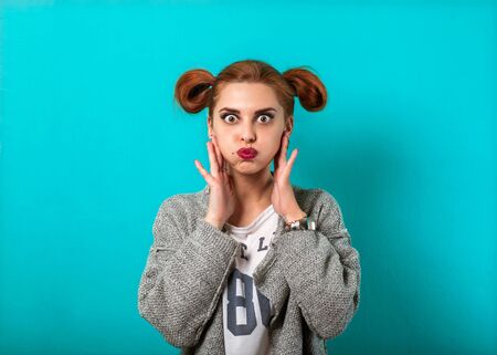 fashion girl in studio near turquoise background smiling and waving his hands emotionally. Vogue...